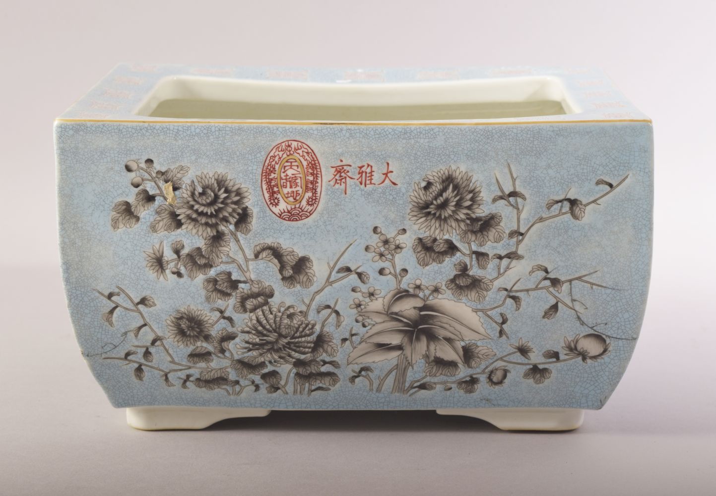 A CHINESE BLUE GROUND RECTANGULAR PORCELAIN PLANTER, decorated with flowers in grey and script, four