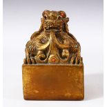 A CHINESE GILT BRONZE SEAL OF A DRAGON - inlaid with simulated coral and turquoise stones - the base