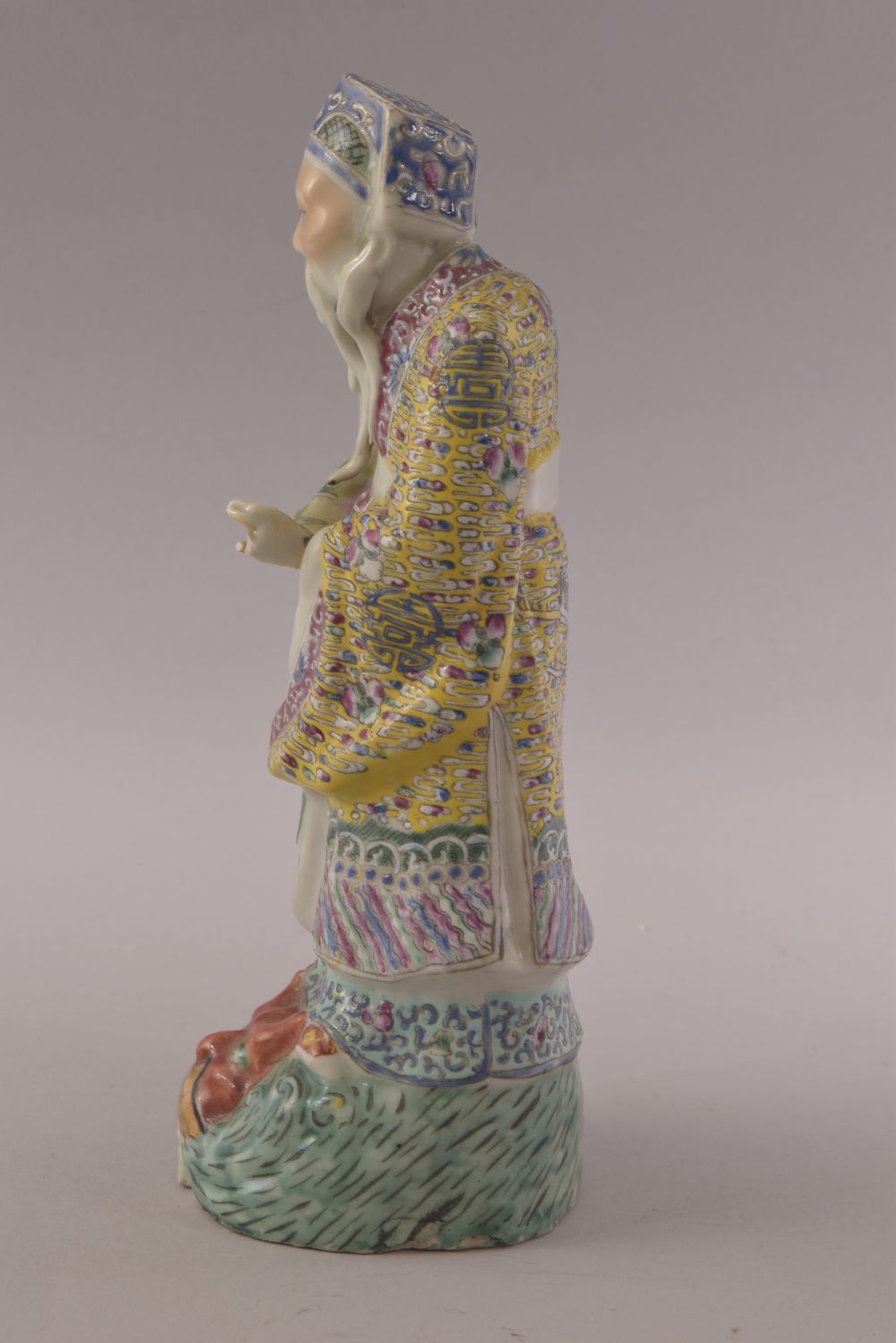 A CHINESE FAMILLE ROSE PORCELAIN FIGURE OF A SAGE, stood upon a wave formation with a mask of a - Image 2 of 8