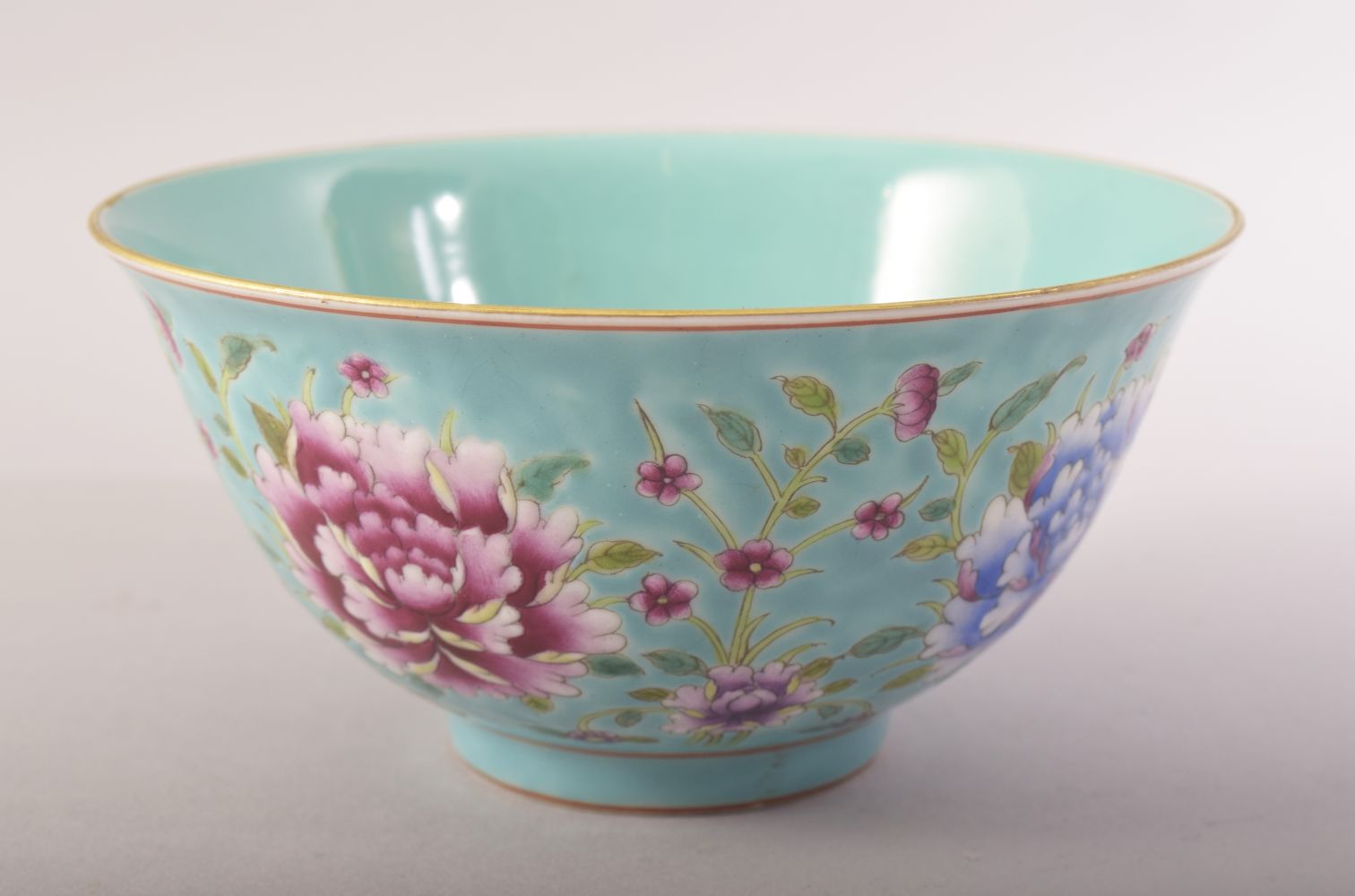 A CHINESE TURQUOISE GROUND / FAMILLE ROSE PORCELAIN BOWL, decorated with flower heads and leaves,