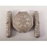 AN ISLAMIC PRAYER / SCROLL BOX - POSSIBLY SILVER, with embossed and chased decoration, 10cm x 8cm.