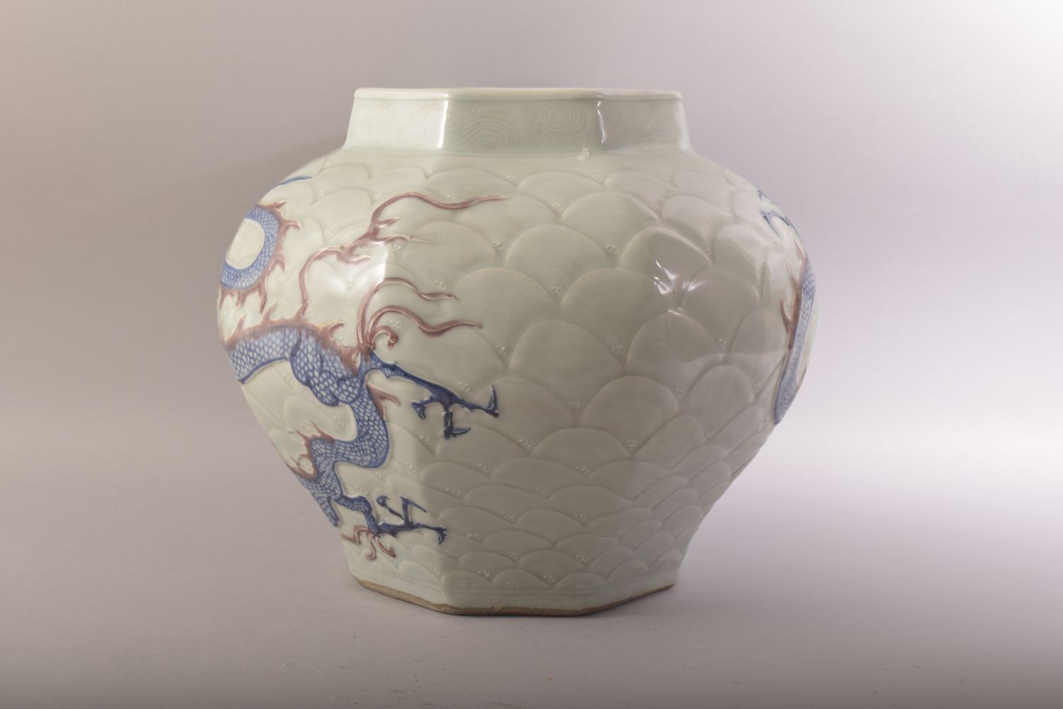A CHINESE MING STYLE CELADON & IRON RED CARVED PORCELAIN JAR - decorated with scenes of dragons upon - Image 2 of 6