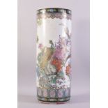 A CHINESE FAMILLE ROSE PORCELAIN WALKING STICK STAND, vividly decorated with peacocks amongst native