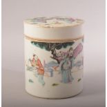 A CHINESE PORCELAIN CYLINDRICAL POT AND COVER, painted with figures in an outdoor setting, 12cm
