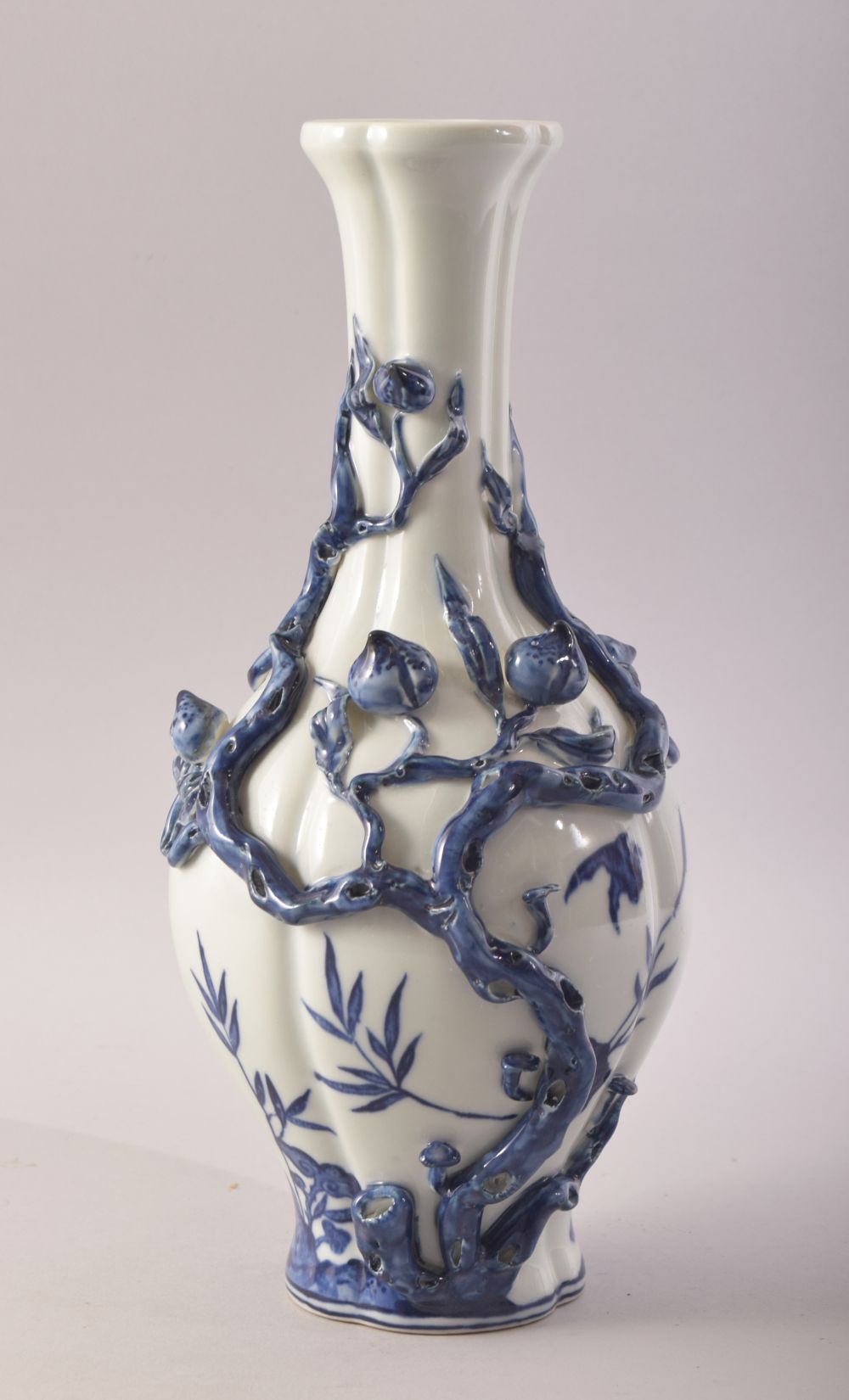 A CHINESE BLUE AND WHITE PORCELAIN VASE, with moulded relief peach tree decoration, the body with
