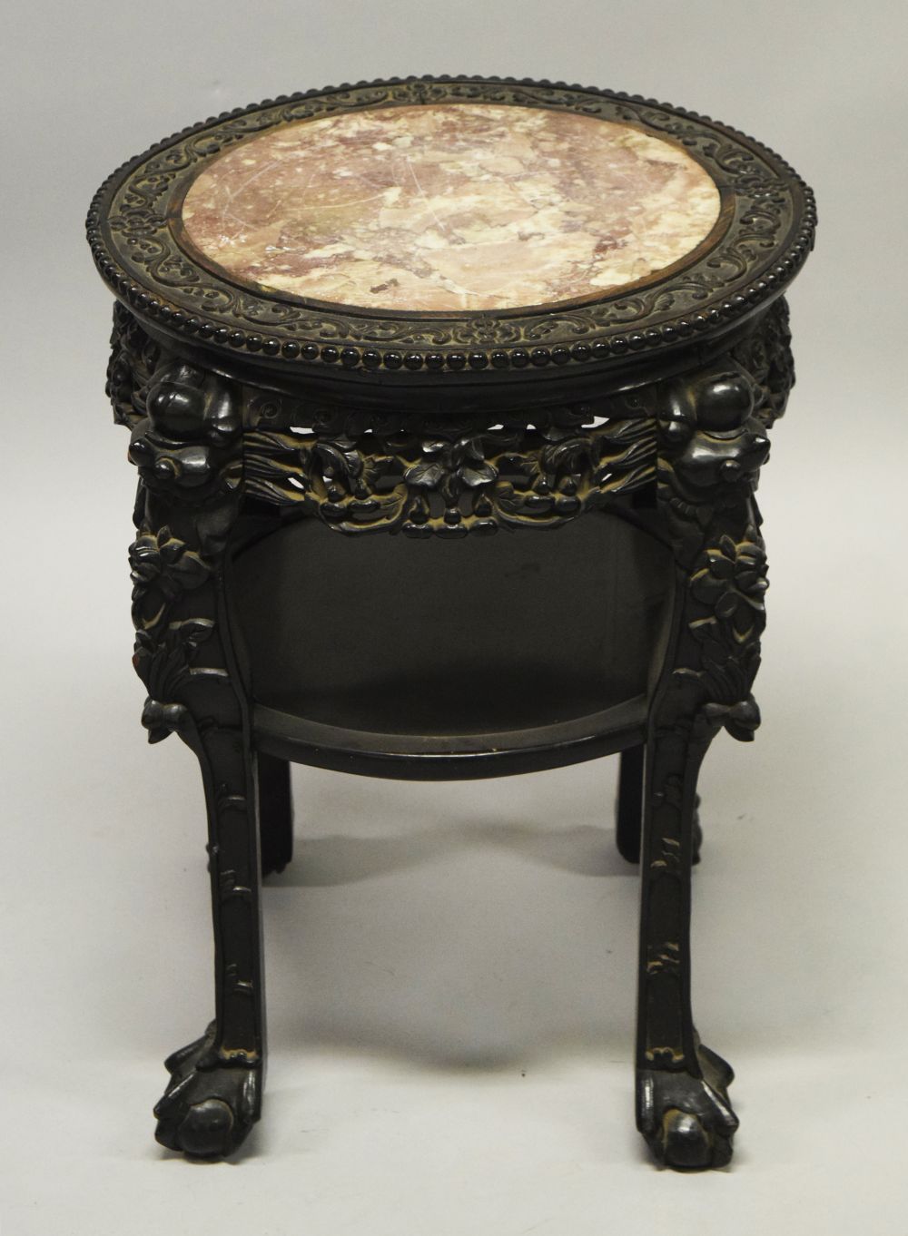 A CHINESE CARVED HARDWOOD MARBLE TOP TWO TIER STAND, the frieze carved with foliate decoration,