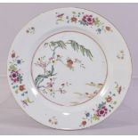 A CHINESE FAMILLE ROSE PORCELAIN PLATE, decorated with native flora, 23cm diameter.