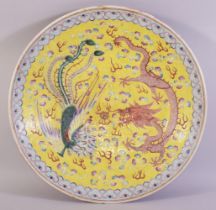 A LARGE CHINESE FAMILLE JAUNE PORCELAIN DISH, the centre painted with dragon, phoenix and the