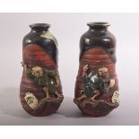 AN UNUSUAL PAIR OF SMALL JAPANESE FIGURAL POTTERY VASES, the rim and neck glazed, with two moulded