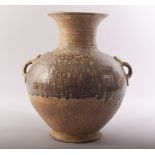 A CHINESE EARTHENWARE TWIN HANDLE POTTERY VASE, the shoulders with treacle glaze, 33cm high.