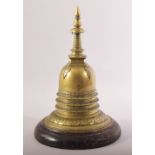 A RARE INDIAN BRASS STUPA, fitted to a wooden stand, 28cm high.