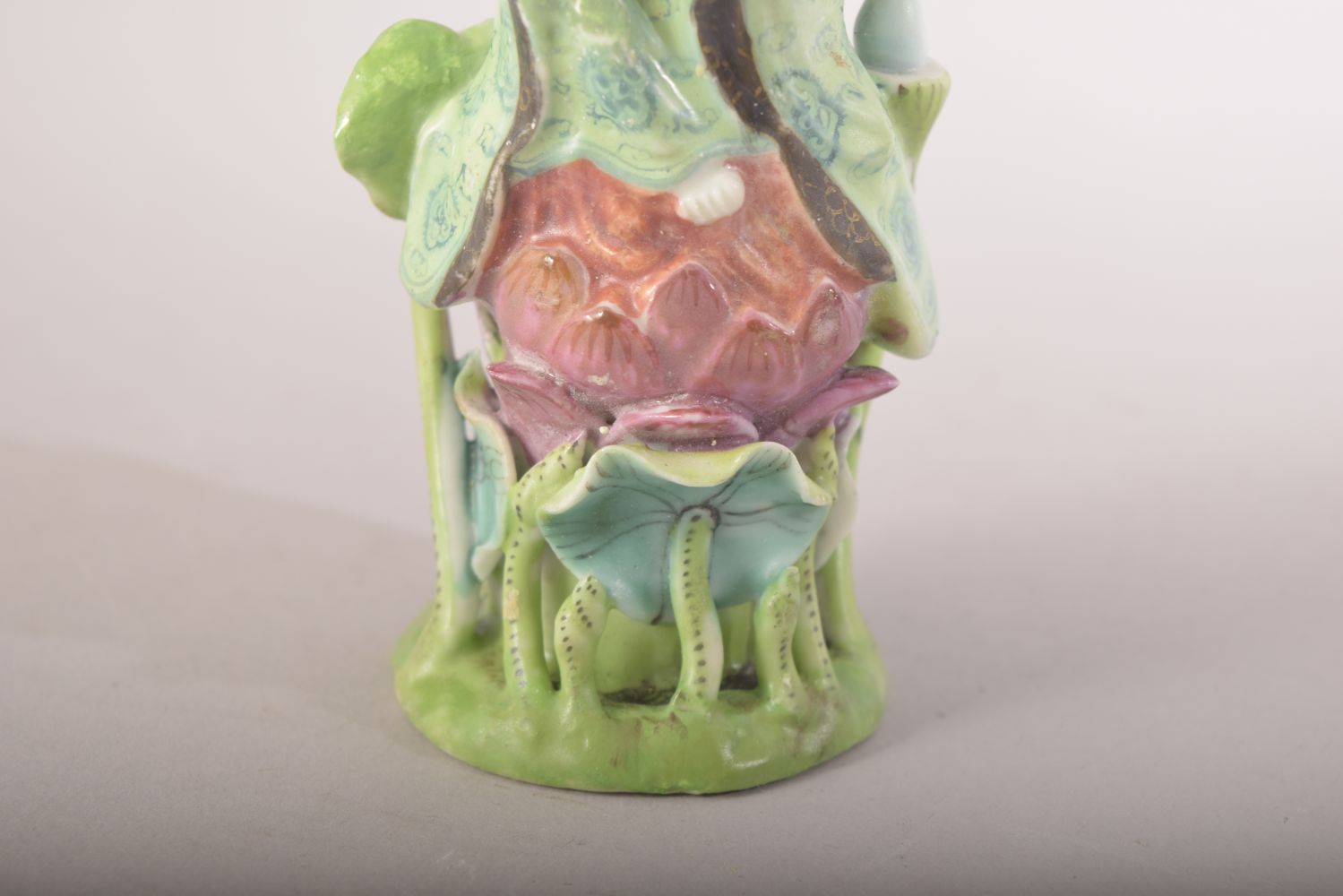 A SMALL CHINESE PORCELAIN FIGURE OF A FEMALE amongst lilies, 13cm high. - Image 6 of 7