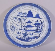 A LARGE CHINESE BLUE AND WHITE PORCELAIN DISH, decorated with buildings, trees and boats, 30.5cm