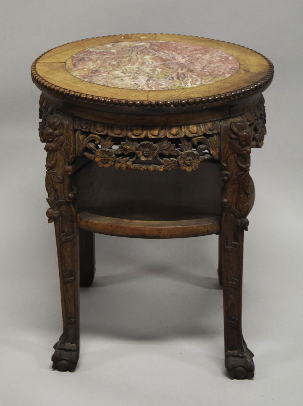 A CHINESE CARVED HARDWOOD MARBLE TOP STAND, the frieze and legs carved with foliate decoration,