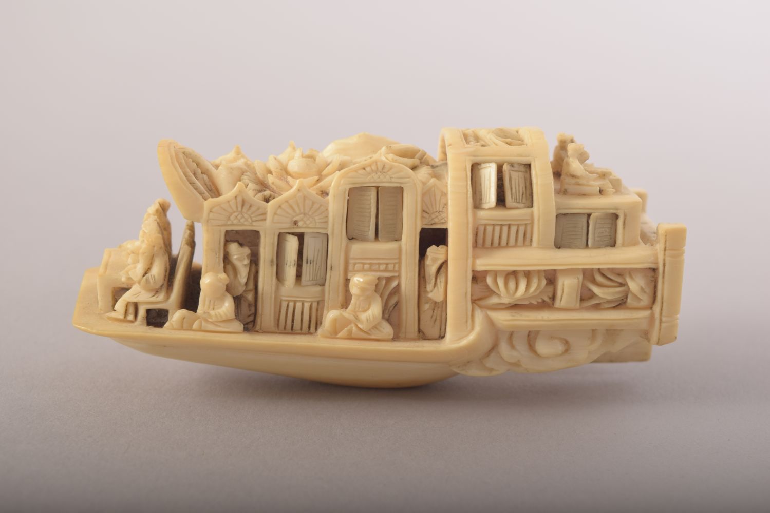 A SMALL CARVED IVORY MODEL OF A JUNK and wooden stand, 8cm long. - Image 4 of 8