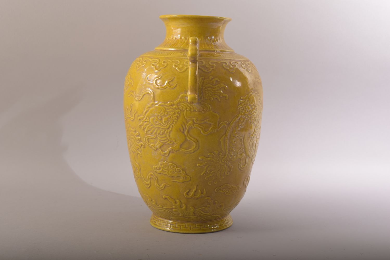 A CHINESE YELLOW GLAZED PORCELAIN TWIN HANDLE JAR - decorated in relief with two lion dogs amongst - Image 4 of 7
