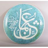 A CIRCULAR GREEN GLAZED CALLIGRAPHIC MOSQUE PLATE, 33cm diameter.