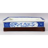 A 19TH CENTURY JAPANESE BLUE & WHITE PORCELAIN PLANTER & HARDWOOD STAND - the planter decorated with