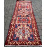 Blue/red ground Iranian runner with starburst design approx 343cm by 101cm