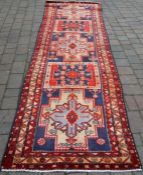 Blue/red ground Iranian runner with starburst design approx 343cm by 101cm