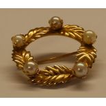 Small circular brooch with leaf & pearl detail marked 14k, width approximately 2.5cm, weight 3.0g