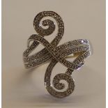 Tested as 14ct white gold (marked 14K) fancy scroll ring set with 68 brilliant cut diamonds, each