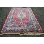 Red ground cashmere carpet with traditional floral pattern approx 308cm by 195cm