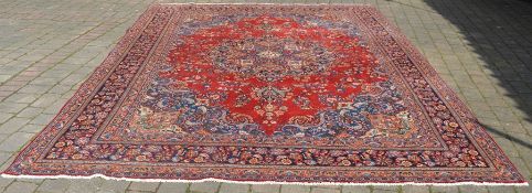 Large red ground Persian Tabriz carpet, multi coloured floral pattern, 390cm x 296cm