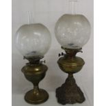 Two cast iron paraffin lamps with etched glass shades