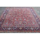 Red ground carpet with geometric design (some damage) 222cm x 305cm