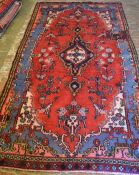 Blue & red ground Persian sarouk carpet with floral medallion (some repairs)  268cm by 145cm