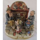 Large Capodimonte figural group consisting of grandparents sitting beside a fireplace with a young
