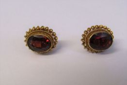 Boxed pair of 9ct gold garnet solitaire earrings, total weight 1.9 g