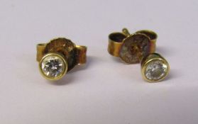 Pair of 18ct gold diamond solitaire earrings, total 0.20 ct (0.10 ct each) with 18ct gold