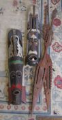 2 large tribal masks H 102 cm and a pair of carved tribal decorative spears H 159 cm (one with