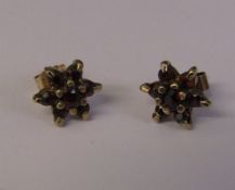 Pair of 9ct gold garnet set star earrings weight 1.1 g