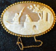 Large cameo brooch depicting landscape with a man in a boat on a yellow metal mount 7.3cm by 5cm