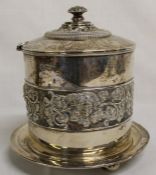 Edwardian silver biscuit barrel on bun feet with fruiting vine and classical head frieze decoration,