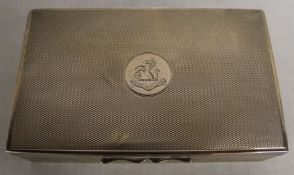 Early 20th century silver cigarette box with engine turned decoration and central heraldic emblem,