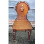 A 19th century carved mahogany hall chair with lozenge back and panel seat
