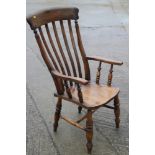 A farmhouse elbow chair with lath back and elm panel seat, on turned and stretchered supports