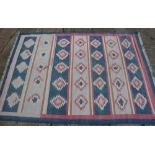 A cotton flatweave rug with geometric design, in shades of blue, pink, sand and natural, 60" x