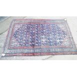 A Middle Eastern rug with floral and central elephant gull designs and multi-bordered on a dark blue