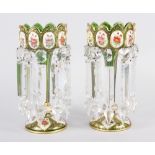 A pair of green glass lustres with gilt and floral panel decoration, hung cut glass spear point