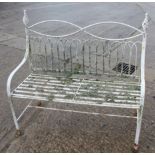 A wrought iron garden settle of Edwardian design with slatted seat, 45" wide