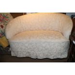 A kidney-shaped two-seat settee with floral loose cover, on square taper supports, 56" wide x 32"
