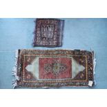 A Kazak style rug with central hook medallion on a red ground and purple field (very faded), 20" x