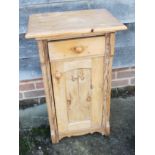A pine bedside cupboard, fitted one drawer over panelled door, 18" wide x 40" deep x 31 1/2" high