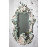 A Continental ceramic framed wall mirror/girandole with candlestick holders, decorated cherubs,