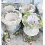 A set of four cast stone campana urns, decorated fern leaves